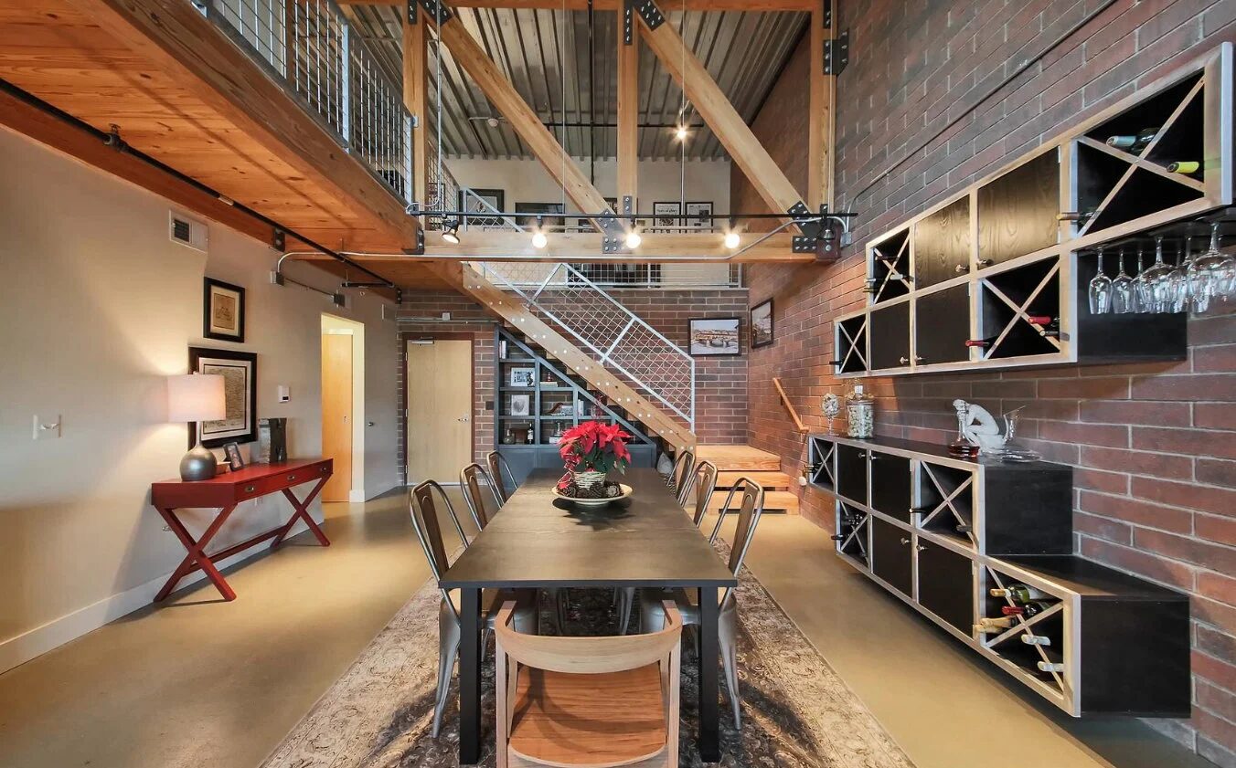 Living area showing soft textiles and warm wood giving depth to the open loft plan