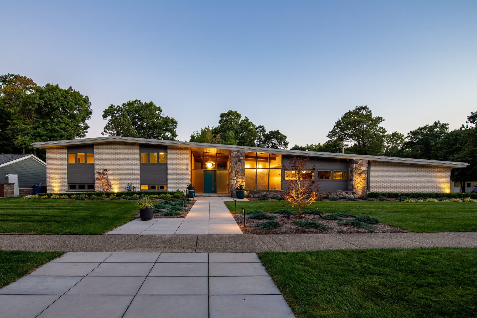 Plymouth Mid-Century residential renovation at dusk showing restored mid-century modern exterior in Rochester Michigan